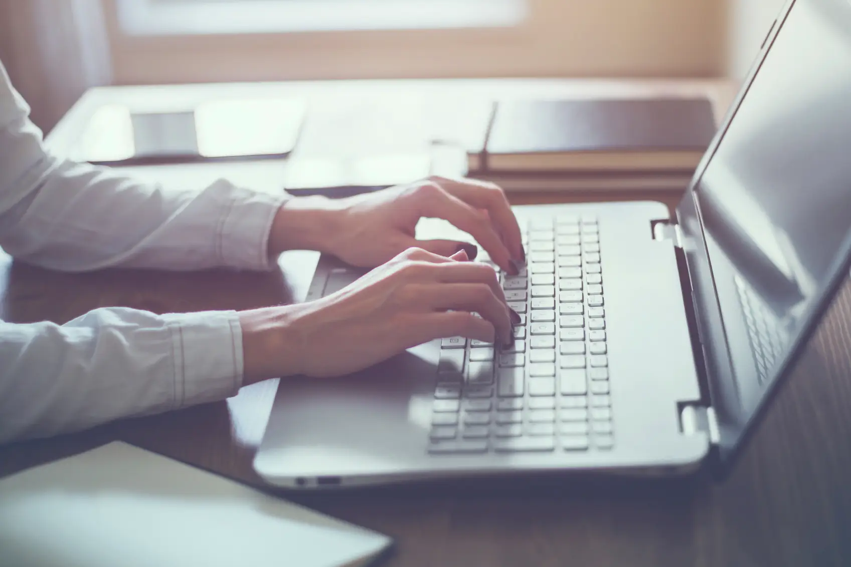 Woman working in home office hand on keyboard close up.